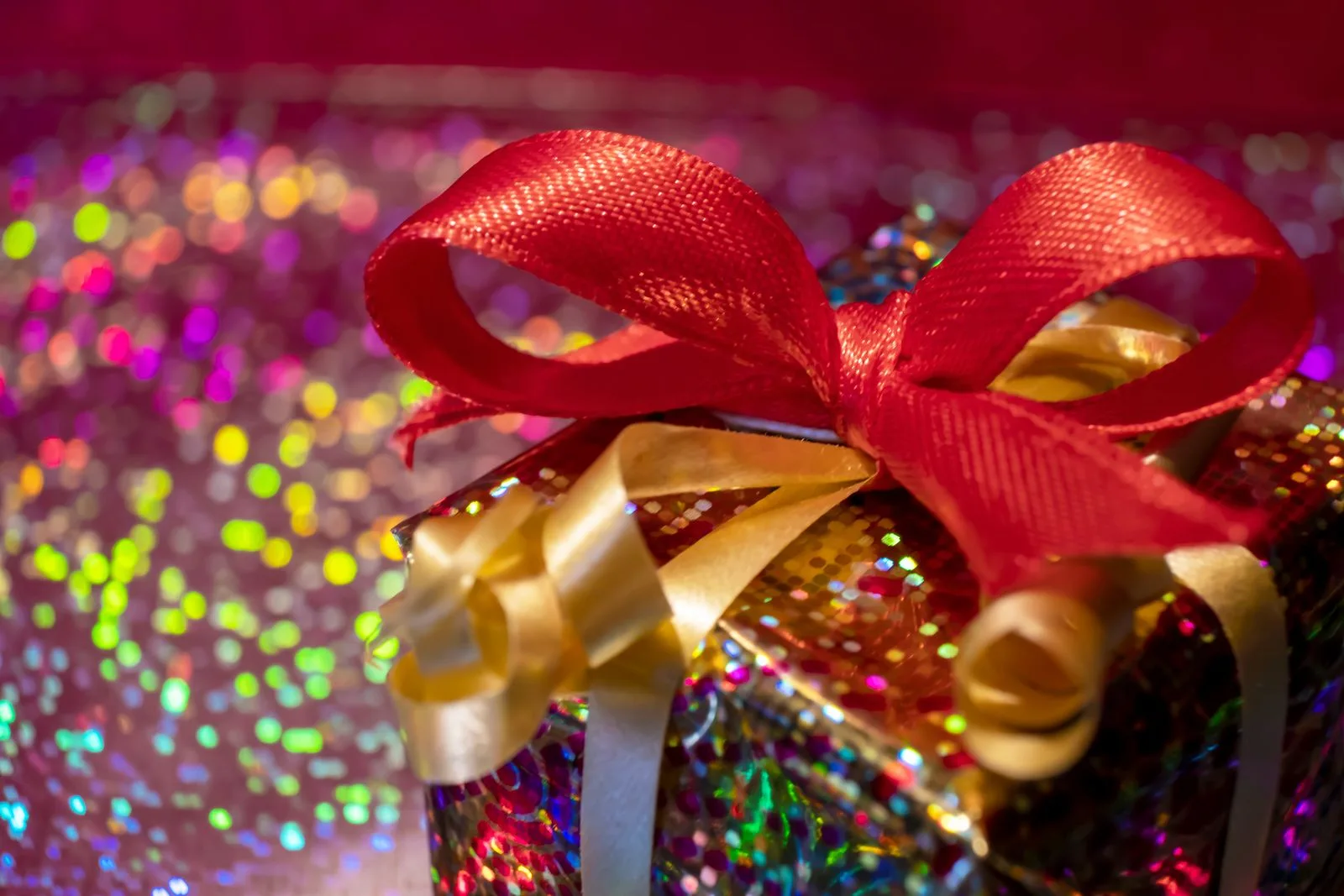 A close view of a wrapped gift with red and gold ribbon.