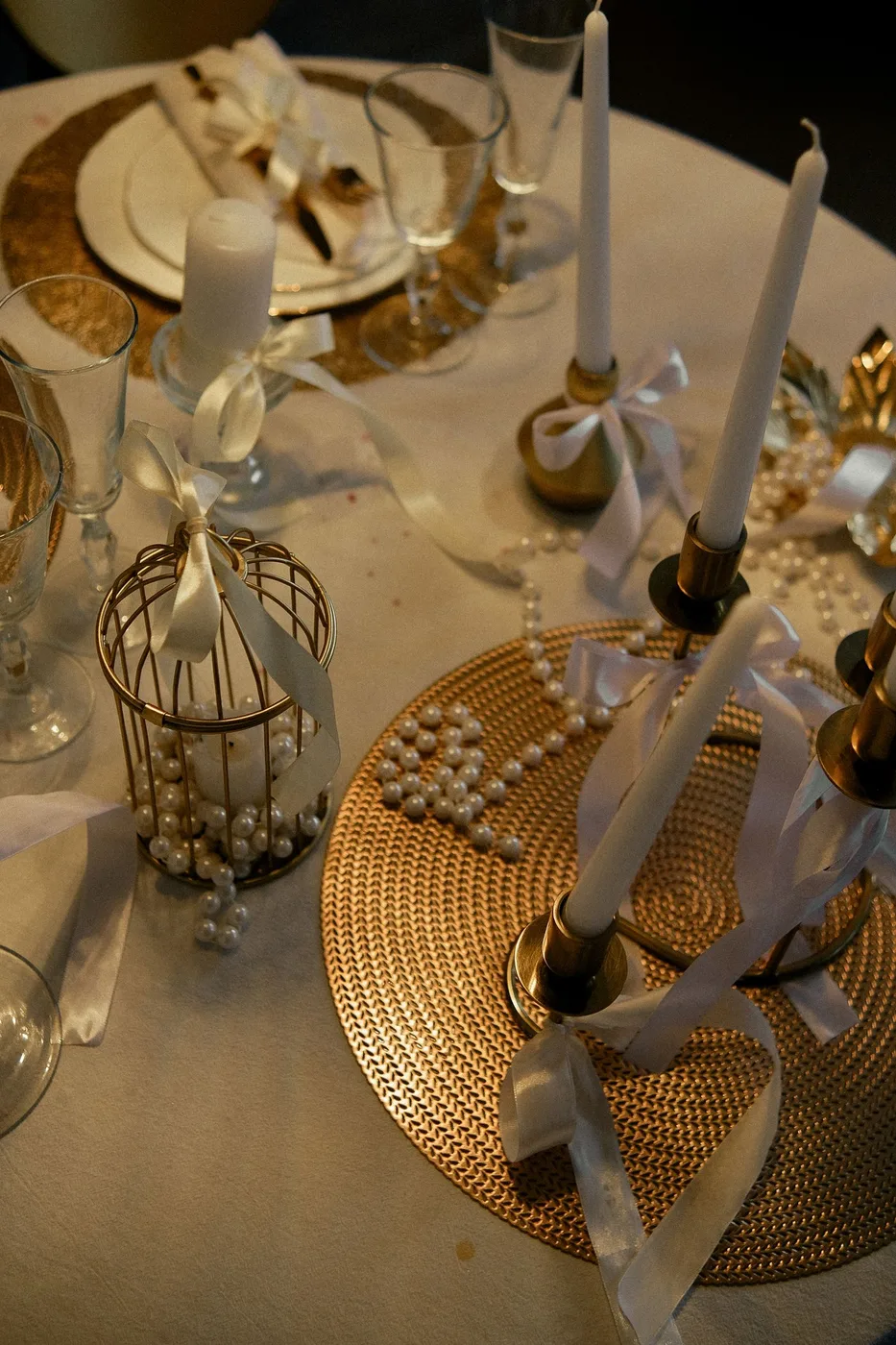 Candles, ribbon and decorative objects arranged on a table.